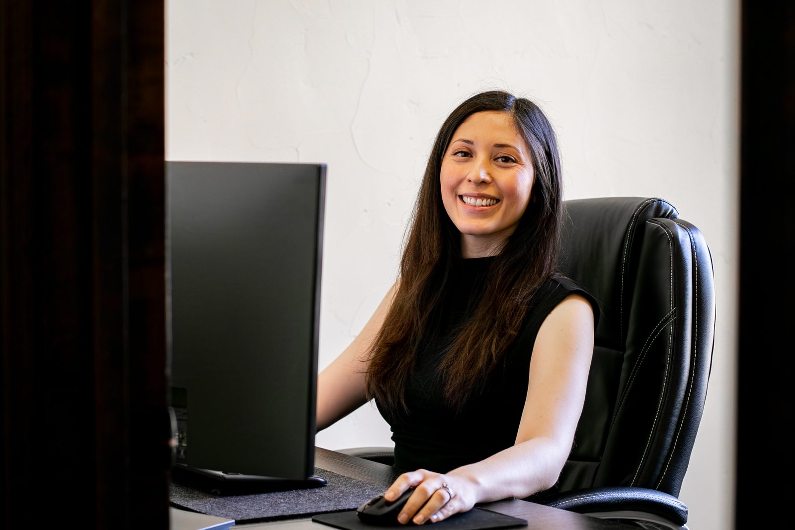 A team member smiling at her desk